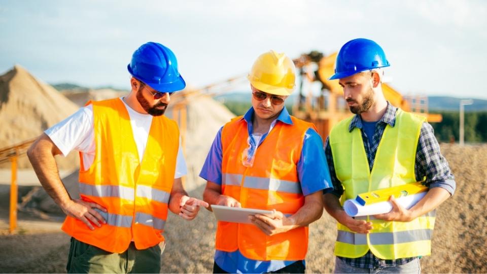 3 mining engineers working on a tablet application - Promine Image